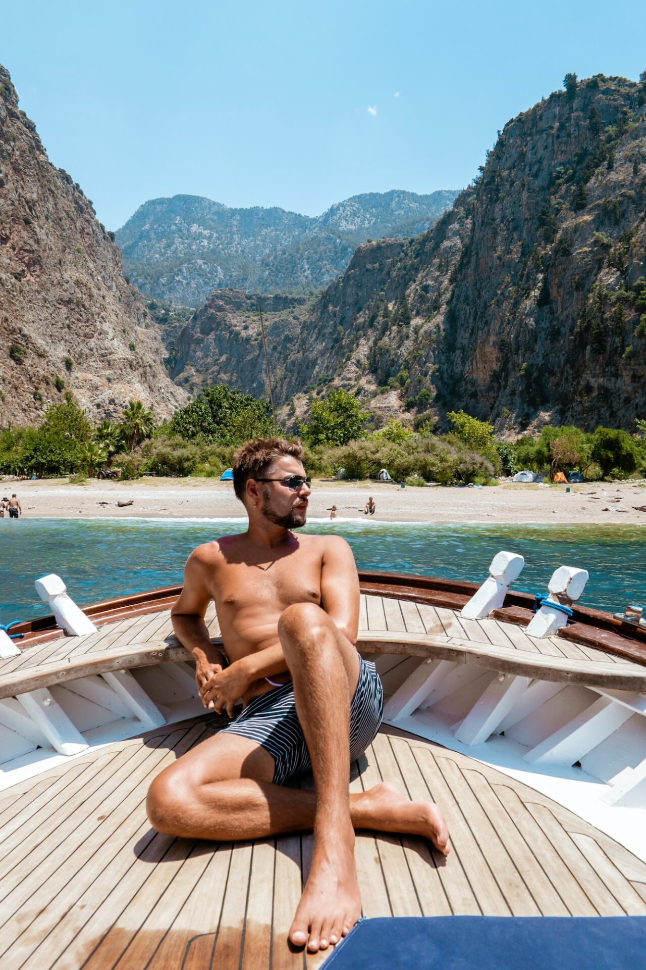 young man relaxing on a wooden boat during a boat trip to Butterfly beach at Fethiye Turkey